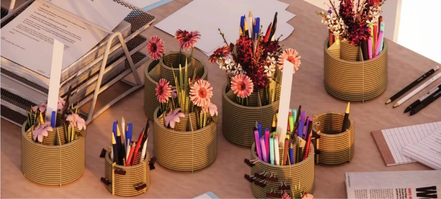 A collection of laser-cut basswood organizers on a desk, holding stationery and flowers
