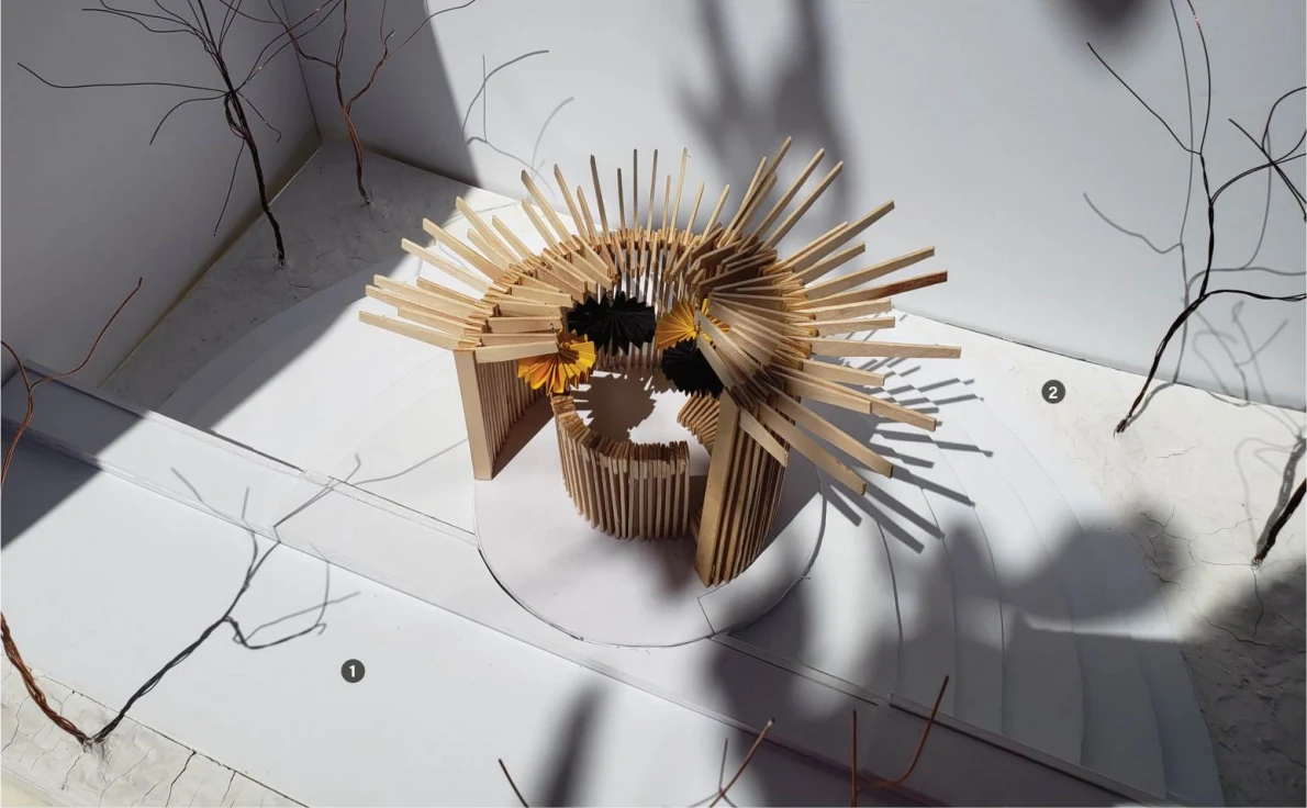 A physical model of a circular timber pavilion with suspended folded paper forms
