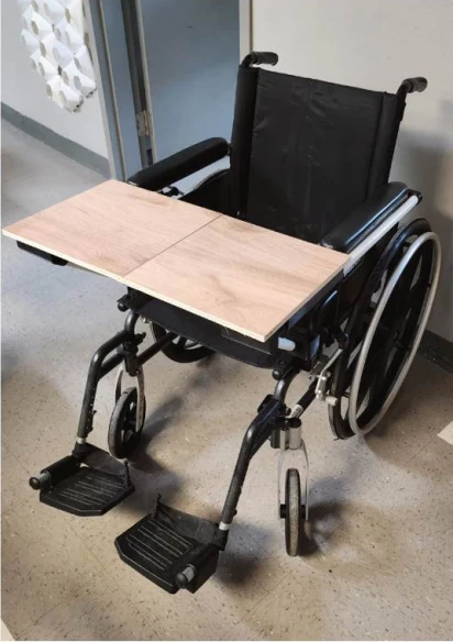 A working prototype of a folding wooden desk mounted to a wheelchair